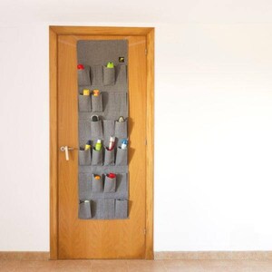 May include: A gray felt over-the-door shoe organizer with 16 pockets. The organizer is hanging on a wooden door and is filled with various items, including bottles of cleaning supplies and other household items.