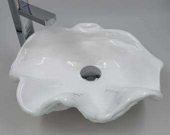 Lavabo de baño con forma de concha gigante, cuenco, encimera, guardarropa, escultura artística en blanco puro.