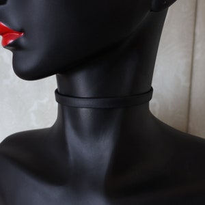May include: A black leather choker necklace on a mannequin.