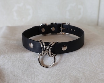 May include: Black leather choker with a silver metal ring and multiple loops.