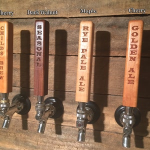 May include: Four wooden beer tap handles with different wood types and engraved text. The handles are labeled "Childs Brew", "Seasonal", "Rye Pale Ale", and "Golden Ale".