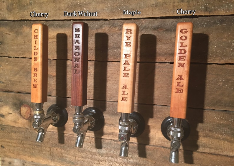 May include: Four wooden beer tap handles with different wood types and engraved text. The handles are labeled "Childs Brew", "Seasonal", "Rye Pale Ale", and "Golden Ale".