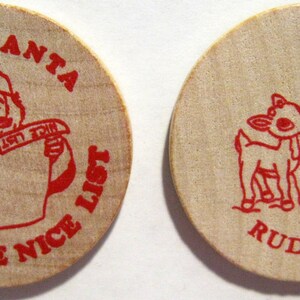 Puede incluir: Dos fichas redondas de madera con texto rojo e ilustraciones. La primera ficha presenta a un Pap&aacute; Noel de dibujos animados sosteniendo un rollo que dice "Nice List" y el texto "I Met Santa I Made The Nice List". La segunda ficha presenta a un reno de dibujos animados con un poste indicador y el texto "Rudolph".