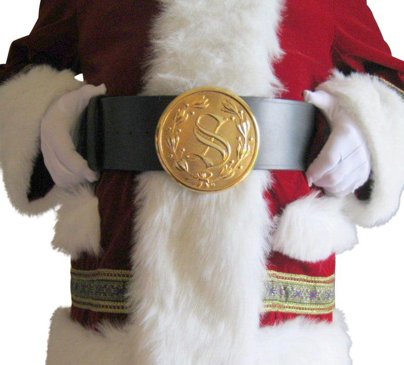 K&ouml;nnte beinhalten: Ein rot-wei&szlig;es Weihnachtsmannkost&uuml;m mit einem schwarzen G&uuml;rtel und einer goldenen Schnalle mit dem Buchstaben "S" umgeben von einem Kranz.