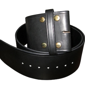 May include: A black leather belt with a brass buckle and rivets. The belt is rolled up and has multiple holes for adjusting the size.