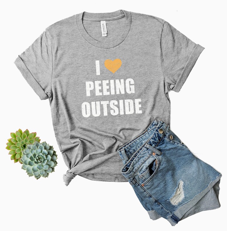 May include: Gray t-shirt with a white heart and the text "I &hearts; Peeing Outside" printed on the front.