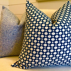 May include: Two decorative throw pillows with geometric patterns. One pillow has a blue and white geometric pattern, and the other has a blue and white speckled pattern.