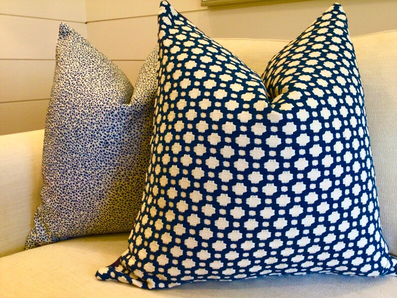 May include: Two decorative throw pillows with geometric patterns. One pillow has a blue and white geometric pattern, and the other has a blue and white speckled pattern.