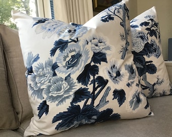 May include: Two decorative throw pillows with a white background and a blue floral pattern. The pillows feature large blue flowers and leaves.