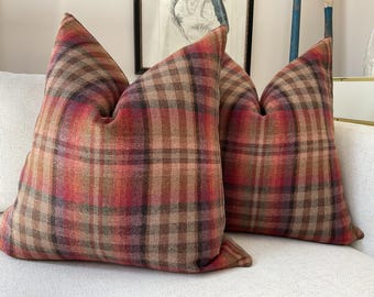 Op de afbeelding: Twee decoratieve kussens met een rood, bruin en beige ruitpatroon.