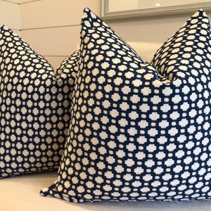 May include: Two decorative throw pillows with a geometric pattern. The pillows are navy blue with a white geometric pattern.