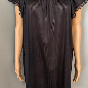 May include: Black, short-sleeved nightgown with vertical stripes. The nightgown has a scoop neckline and lace trim on the sleeves. The fabric appears to be a lightweight, semi-sheer material.
