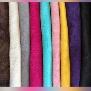 May include: A collection of 12 fabric swatches in various colors, including brown, white, gray, pink, turquoise, yellow, purple, and black. The fabric appears to be suede.