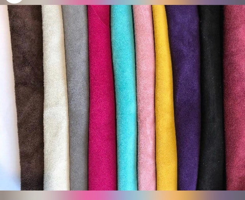 May include: A collection of 12 fabric swatches in various colors, including brown, white, gray, pink, turquoise, yellow, purple, and black. The fabric appears to be suede.