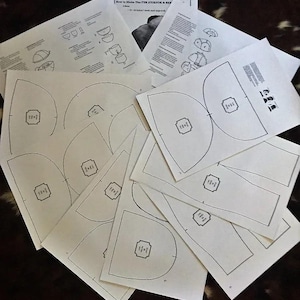 May include: A set of white paper patterns for making a fur aviator hat and a beanie. The patterns are labelled with numbers and include instructions for cutting and sewing.
