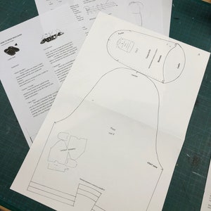 May include: A black and white pattern for making moccasins. The pattern includes instructions for cutting out the foot, the upper, and the leather. The pattern also includes a layout example.