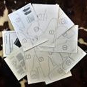 May include: A set of six paper patterns for sewing different styles of clothing. The patterns are printed on white paper and include instructions for cutting and sewing.