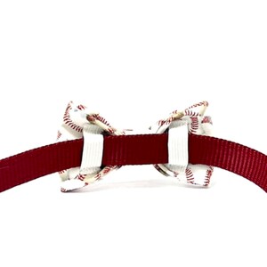 以下が含まれることがあります： 野球をテーマにしたペット用蝶ネクタイ。 蝶ネクタイは、赤い野球のステッチが入った白い生地でできており、バーガンディ色の首輪に取り付けられています。 蝶ネクタイは首輪の中央に配置され、対称的なデザインになっています。