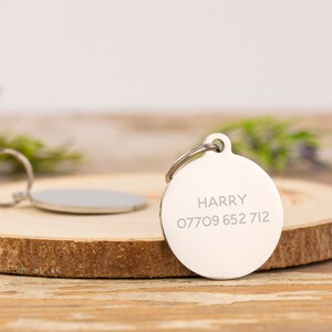 May include: Silver round pet tag with the name "HARRY" and phone number "07709 652 712" engraved on it.