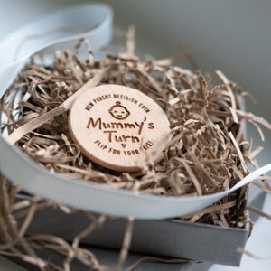 New parent flip wooden decision coin, mummy's turn!