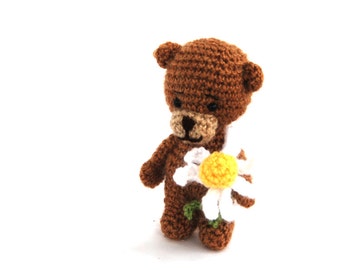 little teddy bear holding an ox-eye daisy flower, tiny tatted animal, bear figurine, miniature fabric, walking bear, animal figurine