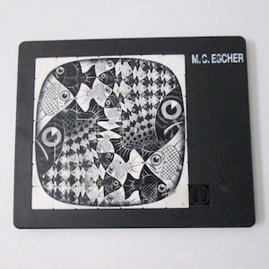 May include: Black and white artwork featuring a tessellation of fish, with the text "M.C. ESCHER" on a black background. The artwork is composed of numerous fish shapes, creating a complex and visually engaging pattern.