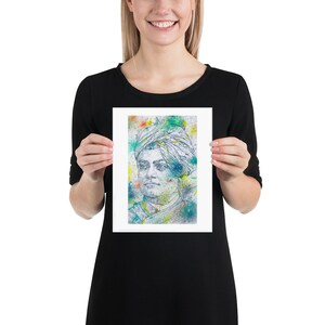 Op de afbeelding: Een ingelijste print van een kleurrijk portret van een man met een tulband. Het portret is gemaakt in aquarelstijl met spatten in blauw, groen, geel en oranje.