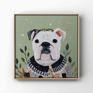 Puede incluir: Pintura enmarcada de un bulldog blanco con un suéter estampado y una corona de hojas. El perro tiene marcas negras en la cabeza y está sobre un fondo verde apagado con motas blancas y hojas verdes.