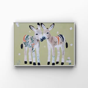 Puede incluir: Una impresión artística enmarcada que presenta dos burros con patrones florales y a rayas. Los burros están representados en un estilo suave y pictórico, sobre un fondo verde claro con flores blancas dispersas. La obra de arte está enmarcada en un marco plateado.