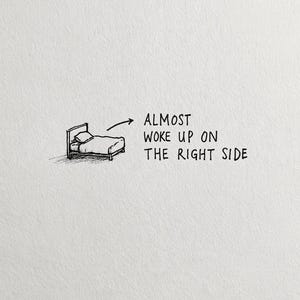 May include: A black and white line drawing of a bed with a pillow and a blanket. An arrow points from the bed to the text that reads: ALMOST WOKE UP ON THE RIGHT SIDE. The illustration is rendered in a simple, hand-drawn style on a plain white background.