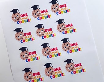 May include: Sheet of stickers featuring a smiling cookie wearing a graduation cap. The text "ONE SMART COOKIE!" is displayed in colorful letters. The stickers are on a white background.