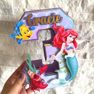 May include: A rustic wooden sign with the text "Welcome to our home" in white lettering. The sign features a distressed finish and a simple, inviting design, perfect for entryway decor.