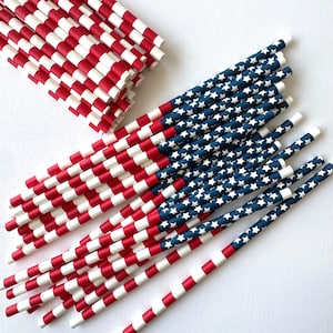 Op de afbeelding: Een verzameling papieren rietjes met een patriottisch thema. De rietjes hebben rood-witte strepen en blauwe secties met witte sterren, die lijken op de Amerikaanse vlag. Deze decoratieve rietjes zijn perfect voor themafeesten en evenementen.