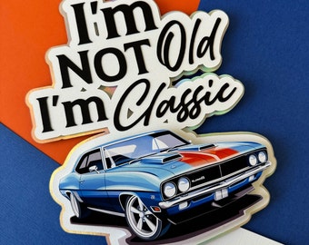 May include: A blue and red muscle car cake topper with the text "I'm Not Old I'm Classic" on a white background.