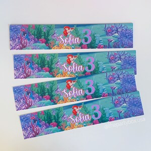 Puede incluir: Cuatro enfriadores de botellas de bebidas de agua azul, morado y verde con una imagen de sirena y el nombre "Sofia" y el n&uacute;mero "3" impresos en cada uno.