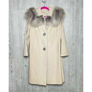 May include: A cream-colored wool coat with a large, fluffy white fur collar. The coat has a button closure and two pockets.