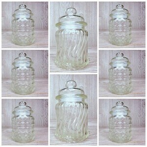 May include: Nine clear glass jars with lids. Some jars have a textured surface and some have a swirl design.