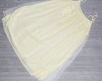 May include: A pale yellow sheer nightgown with delicate floral embroidery. The gown has thin straps and a flowing silhouette.