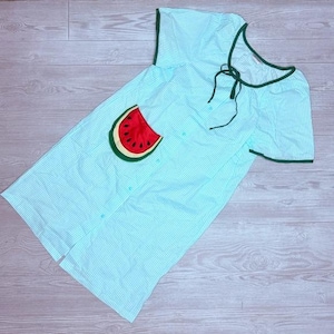 May include: Light blue striped sleep shirt with a watermelon pocket design. The sleep shirt has short sleeves and green trim around the neckline and sleeves. The shirt has a button-up front and a tie at the neckline.