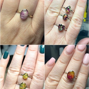 K&ouml;nnte beinhalten: Vier goldene Ringe mit verschiedenen Formen aus Harz, in denen gepresste Blumen eingearbeitet sind. Die Ringe werden an verschiedenen H&auml;nden gezeigt.