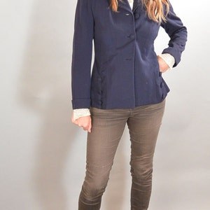 May include: A woman wearing a navy blue blazer with brown pants and brown open-toe heeled shoes.