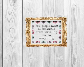 May include: A gold framed picture with a white background and black text that reads "You people must be exhausted from watching me do everything." The text is surrounded by a colorful floral pattern.