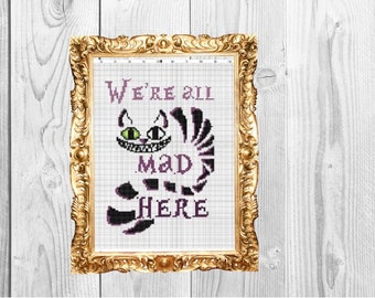 Puede incluir: Patrón de punto de cruz con el Gato de Cheshire de Alicia en el País de las Maravillas. El patrón incluye la cita "We're all mad here" y una imagen en negro y morado del Gato de Cheshire.