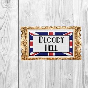 May include: A framed cross-stitch with a Union Jack flag background and the text "BLOODY HELL" in black letters.