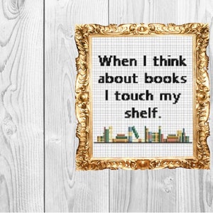 Pode incluir: Uma imagem emoldurada em ouro com fundo branco e texto preto que diz "Quando penso em livros, toco na minha estante." A imagem também tem uma fileira de livros coloridos na parte inferior.