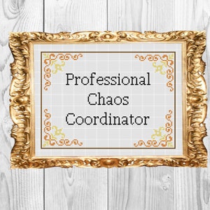 May include: A framed cross-stitch with a gold frame and a white background. The cross-stitch reads "Professional Chaos Coordinator" with a decorative border.