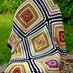 May include: A colorful crocheted throw blanket with a black background and a geometric pattern. The blanket is made of squares with different colors and designs, including yellow, red, orange, green, and purple.
