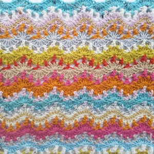 May include: Multicoloured crochet trim with a wavy edge. The trim features a variety of colours, including turquoise, pink, orange, yellow, and gold.