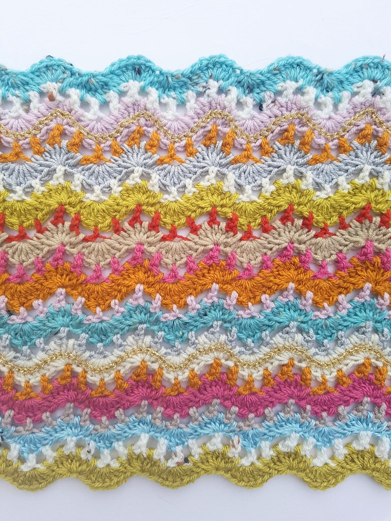 May include: Multicoloured crochet trim with a wavy edge. The trim features a variety of colours, including turquoise, pink, orange, yellow, and gold.