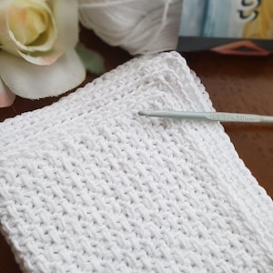 May include: White crocheted fabric with a crochet hook labeled "US 7 4.50mm".